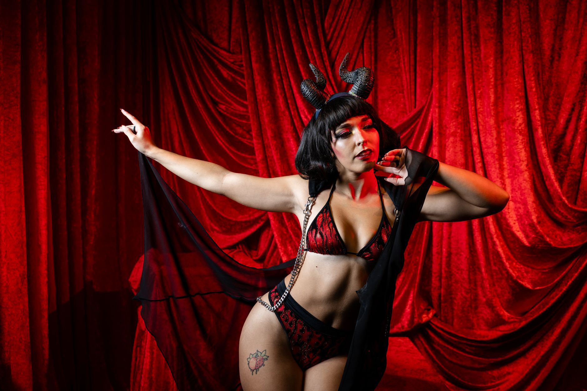 Performer in an elaborate burlesque-inspired stage costume under dramatic lighting