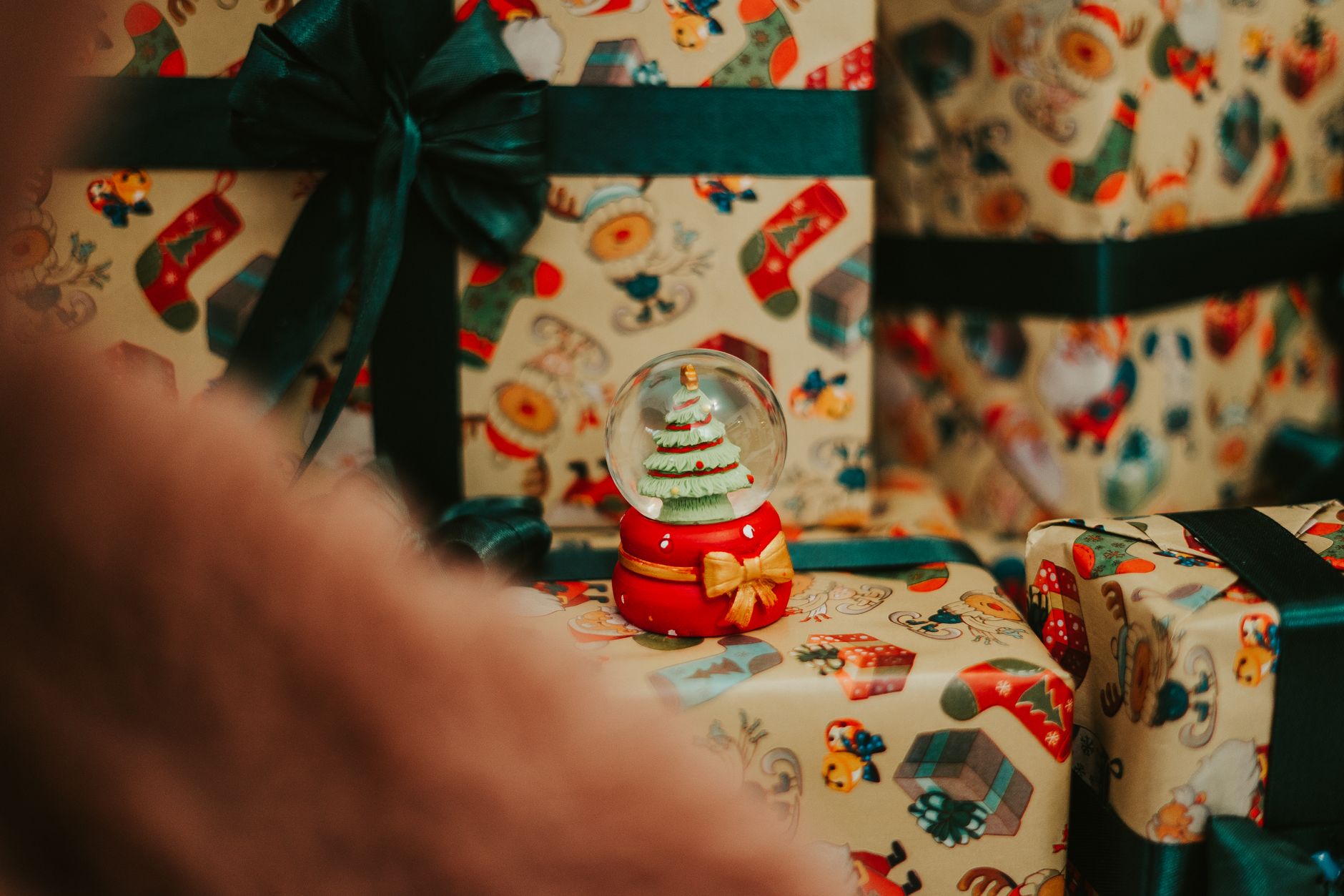 Filled Christmas stockings hanging near a fireplace with small wrapped gifts