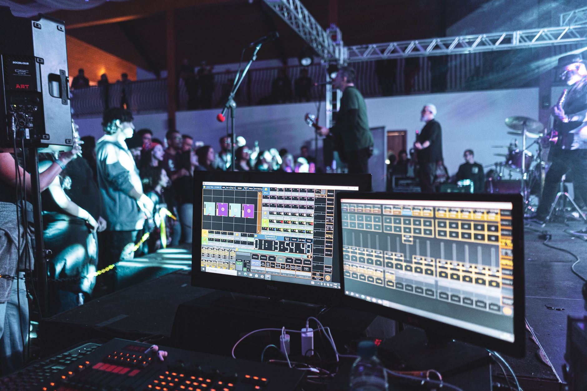 Wide shot of a large theater stage illuminated by colorful concert lighting