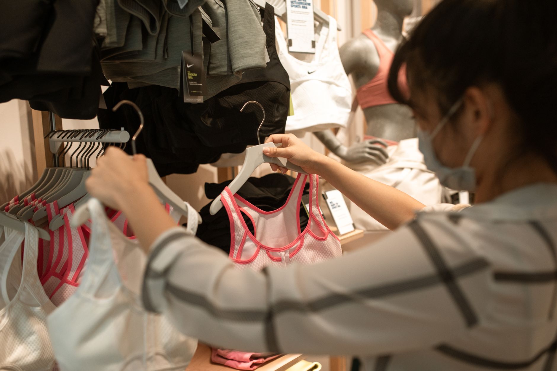 Consumer browsing sneakers in a sportswear retail environment