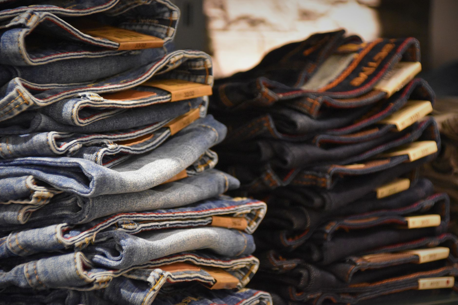 Relaxed fit loose jeans laid flat on a neutral surface